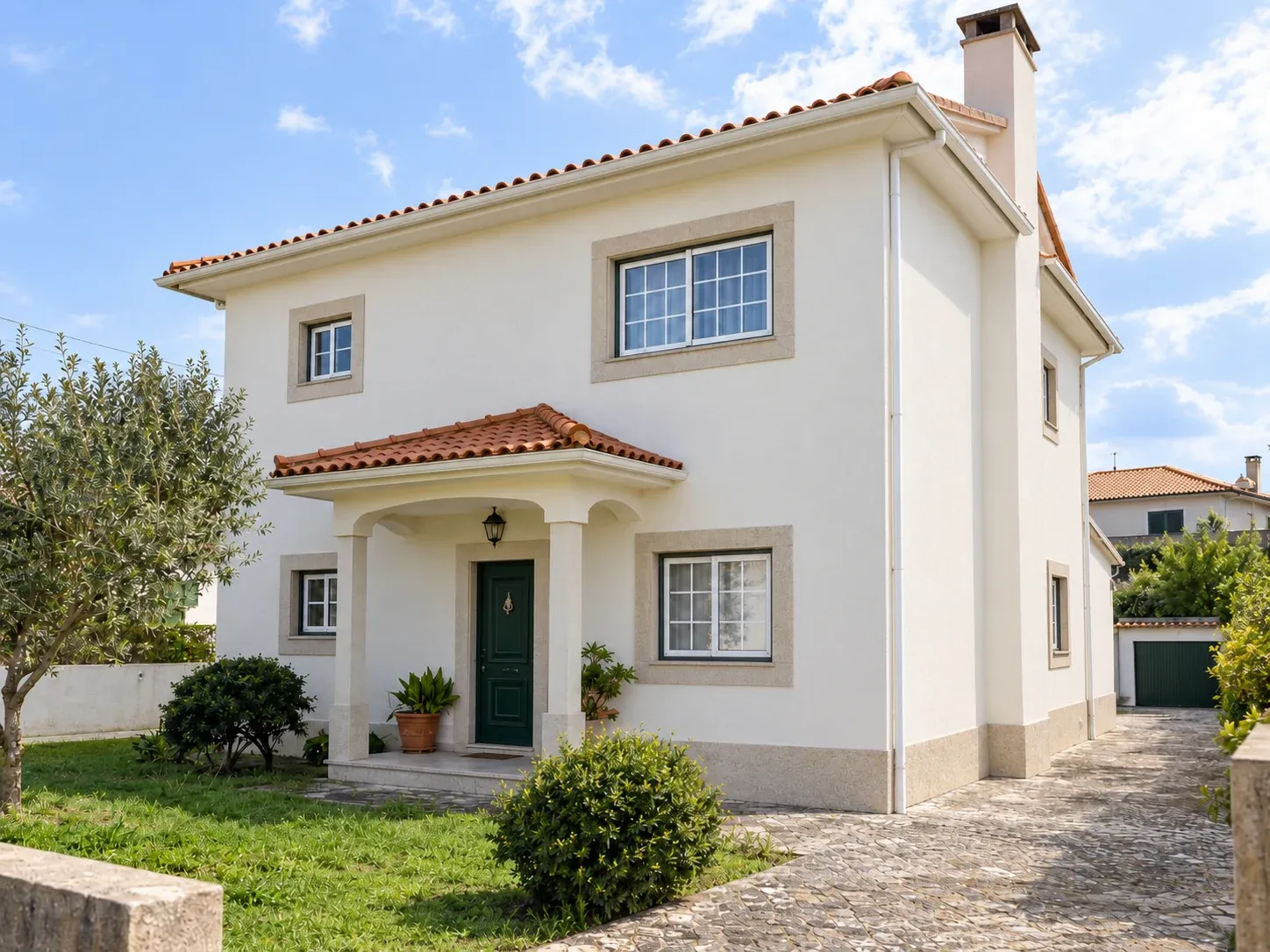Fachada de moradia com acabamento contínuo e soco definido