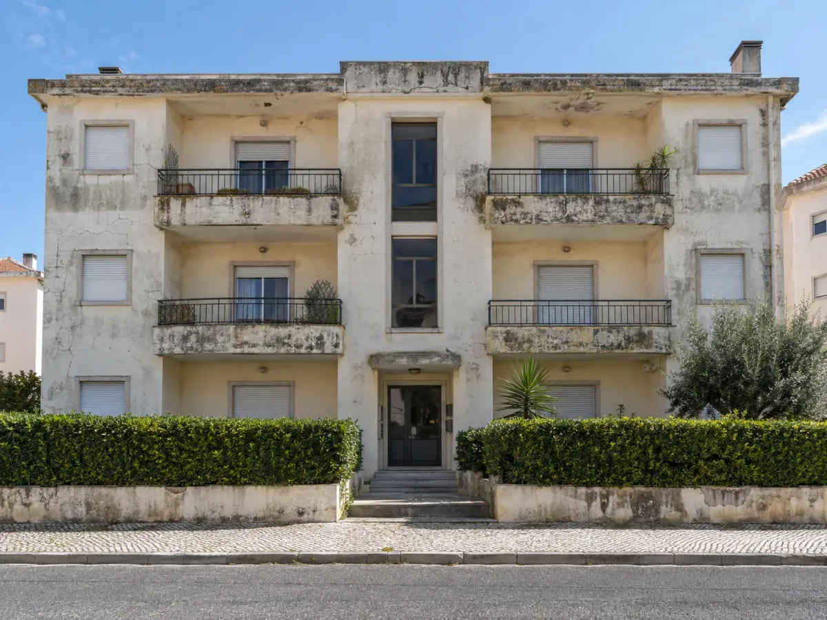 Fachada frontal de prédio com fissuras e algas no paramento